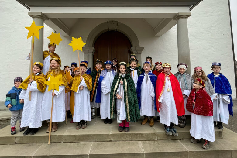 Gruppenbild der Sternsinger vor der Kirche